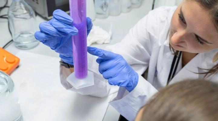 noia al laboratori amb una proveta 